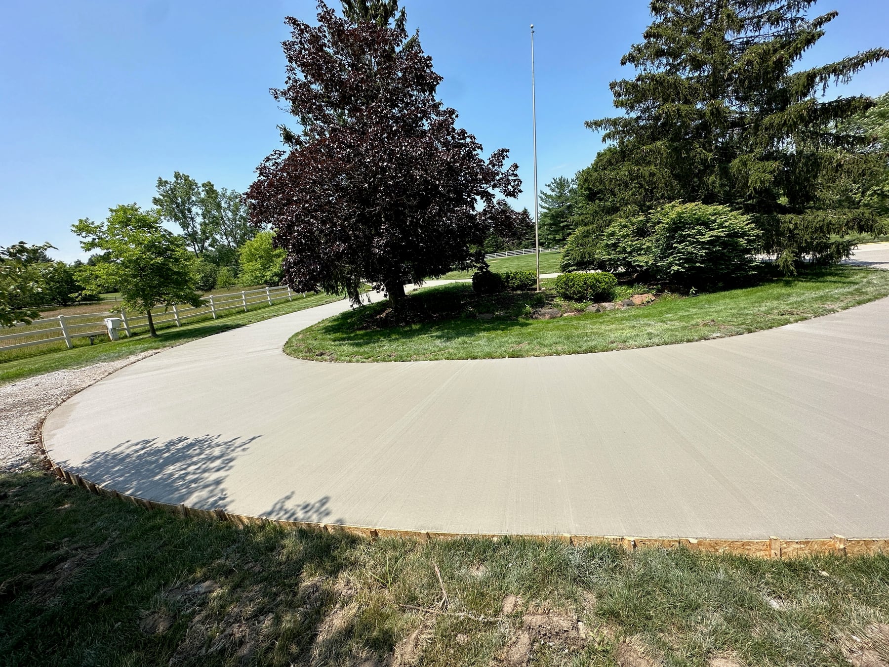 Finished curved concrete driveway installed by Upmost Cement